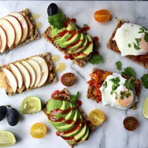 sliced avocado and apple on rye crackers