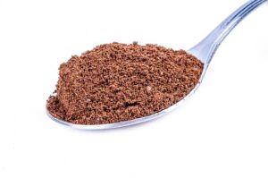 raw cacao powder on a silver spoon